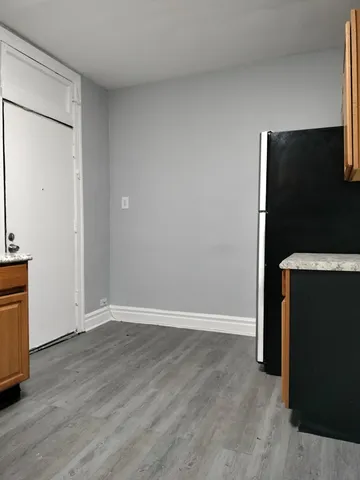 a view of an empty room with wooden floor and a cabinet