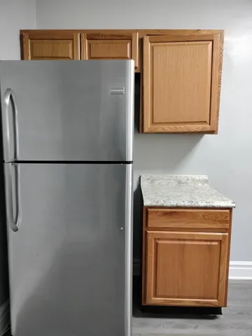 a close view of a refrigerator in kitchen and wooden floor