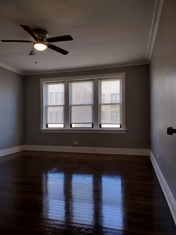 a living room with wooden floor and a window