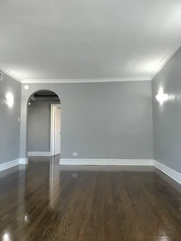 an empty room with wooden floor and mirror
