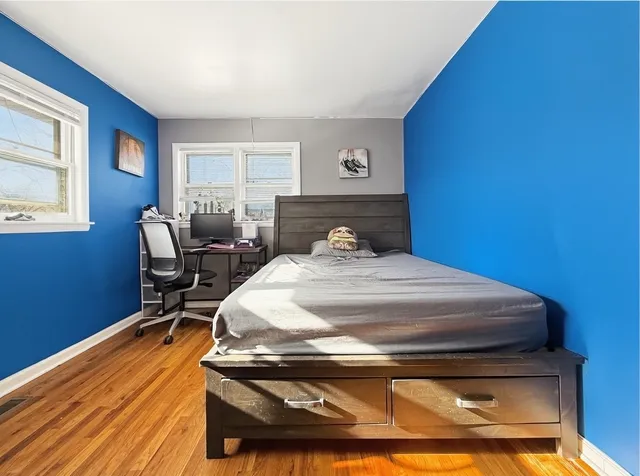 a bedroom with a bed and windows