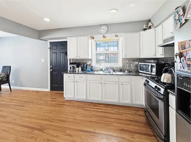 a kitchen with stainless steel appliances granite countertop a sink stove and refrigerator