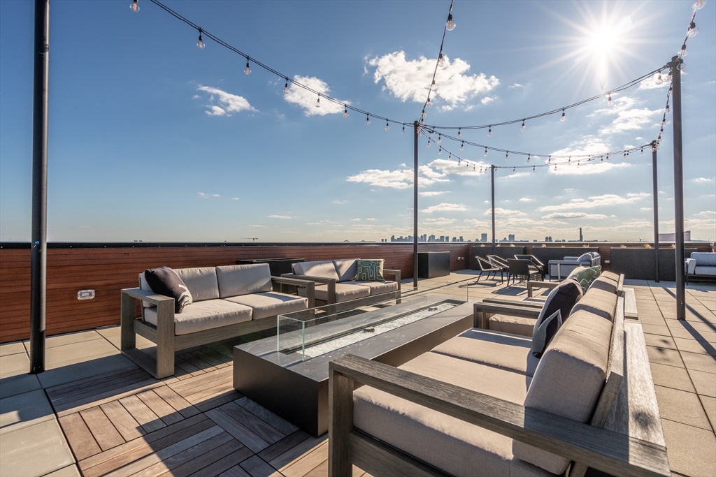 600 Broadway, Unit 513 Chelsea, MA 02150 - Photo 22 of 31 a living room with patio furniture and a chandelier