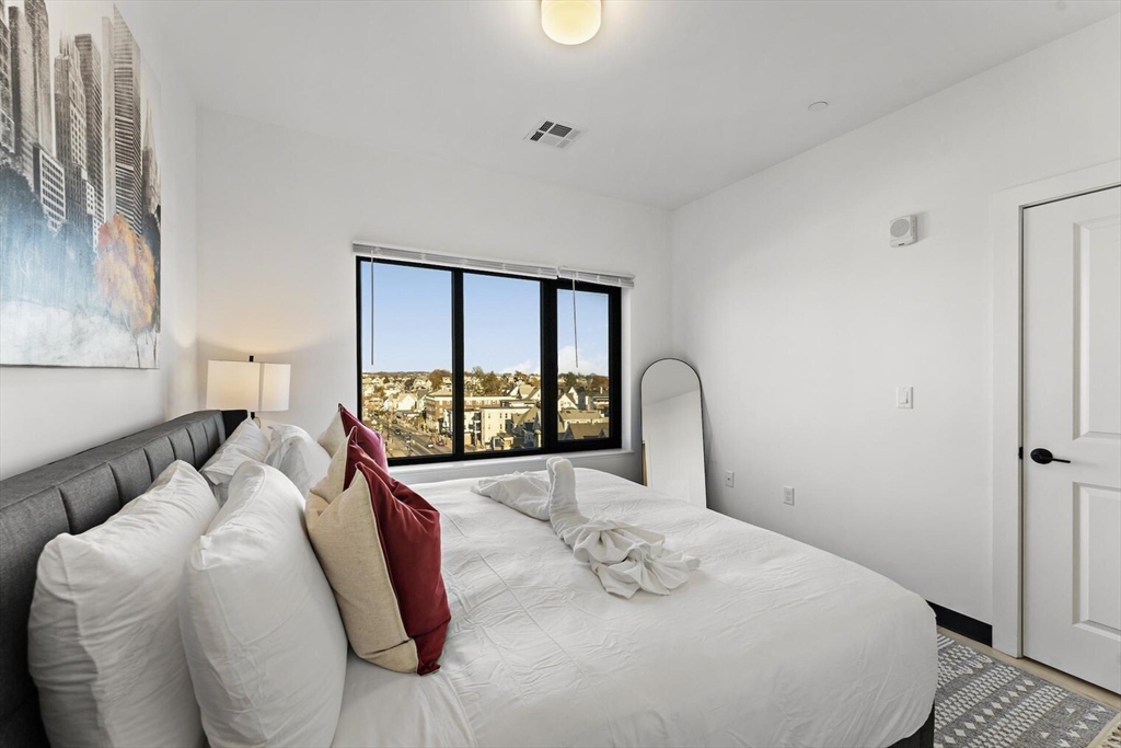 600 Broadway, Unit 513 Chelsea, MA 02150 - Photo 9 of 31 a bedroom with a large bed and a large window