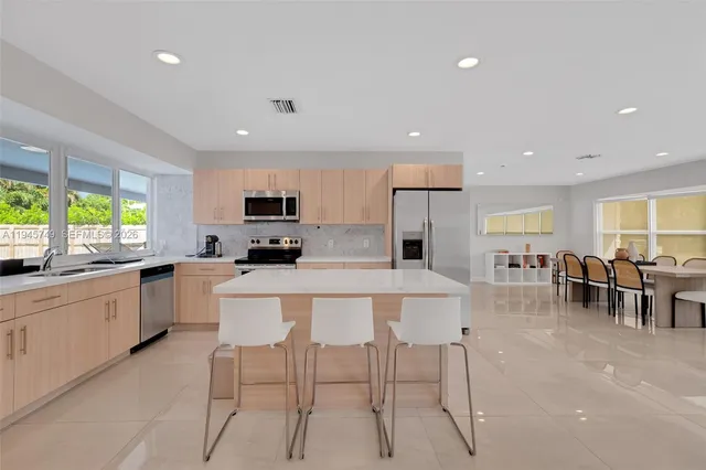 a kitchen with appliances a sink a counter top space and cabinets