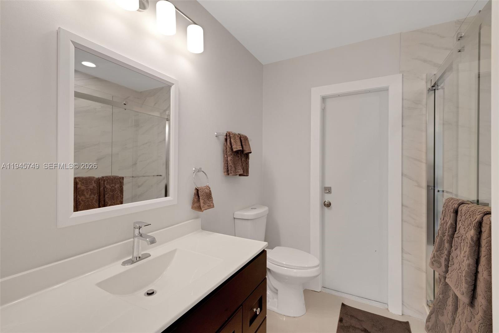 3500 North Park Road Hollywood, FL 33021 - Photo 18 of 39 a bathroom with a toilet a sink a light fixture and a mirror
