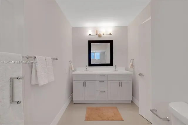 a bathroom with a sink a toilet and mirror