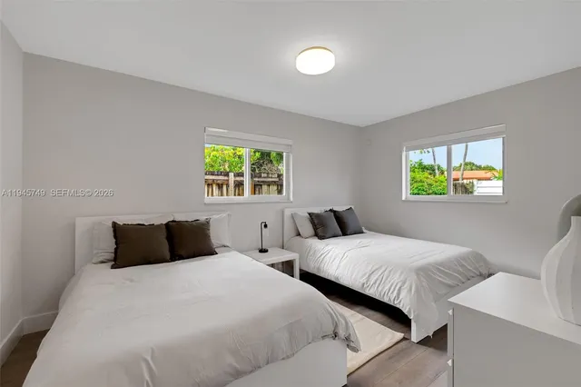 a bedroom with two beds and a window