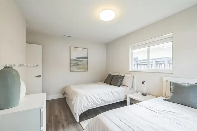 a bedroom with two beds and a window