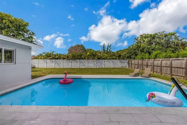 a view of swimming pool with outdoor seating and yard