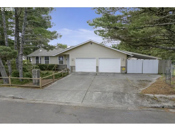 a view of a house with a yard and large tree