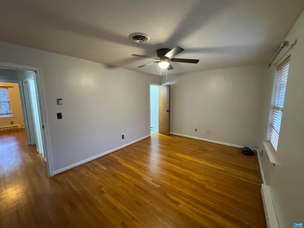 a view of an empty room with wooden floor