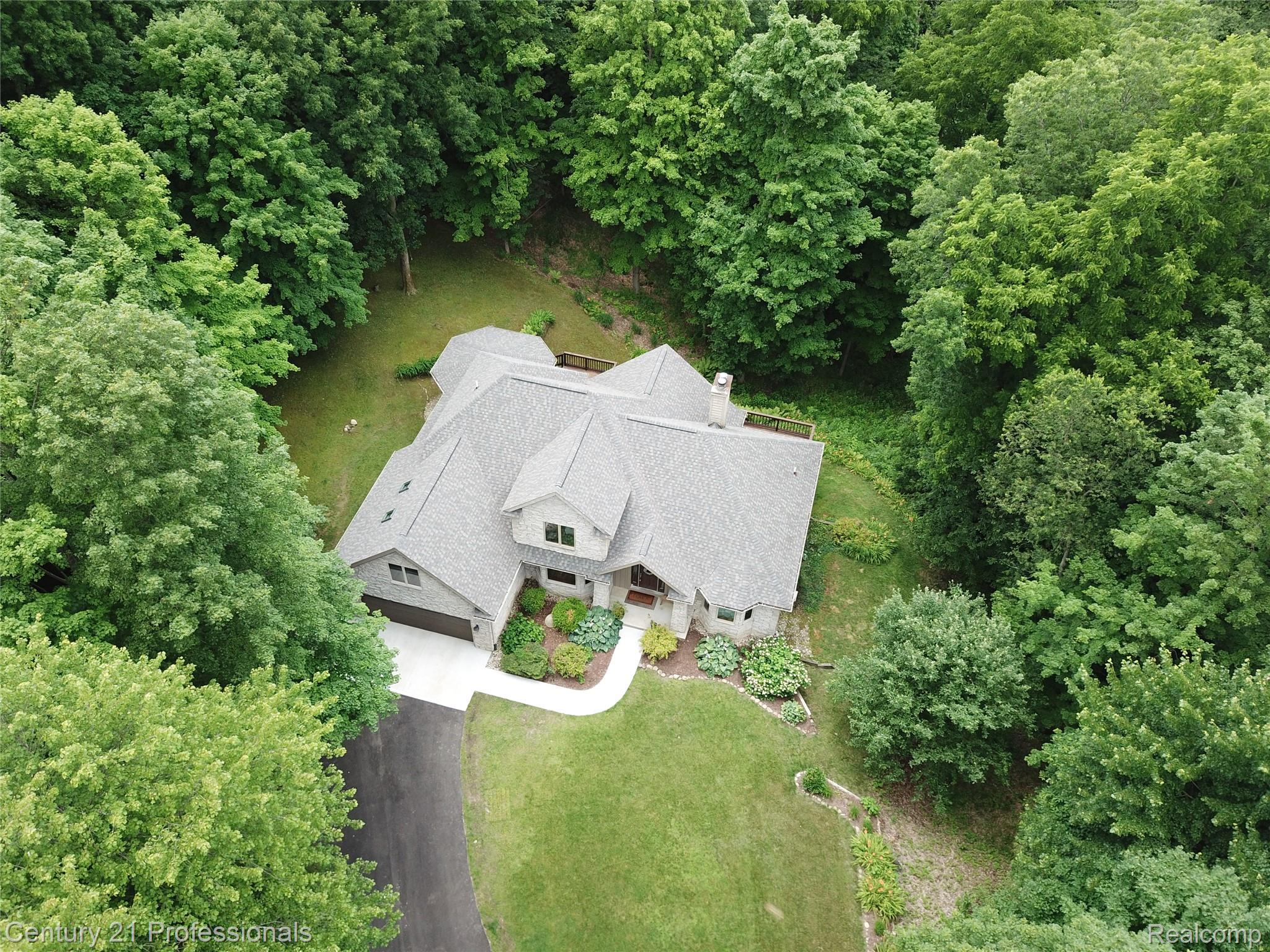9867 Rainbow Ridge Drive Schoolcraft, MI 49087 - Photo 8 of 82 Expansive property featuring a multi-gabled roofline, mature tree coverage, a paved driveway, manicured lawn, and lush landscaping
