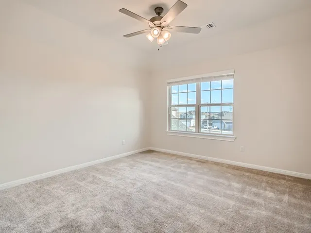 an empty room with a window and a fan