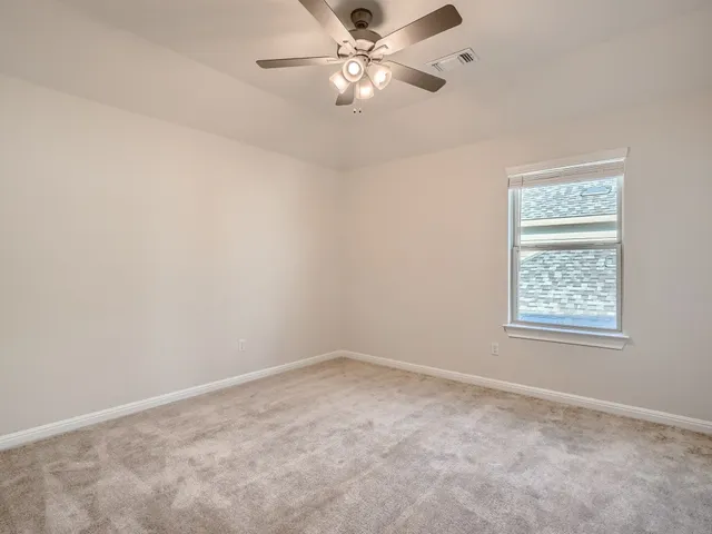 an empty room with a window and a fan