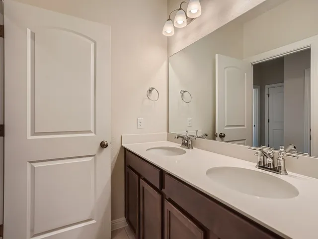 a bathroom with a double vanity sink and a mirror