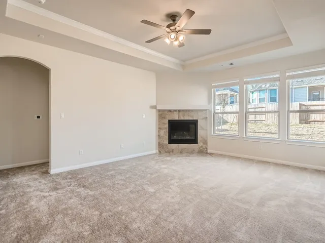 an empty room with windows and fireplace