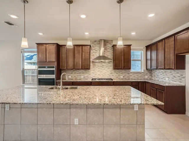 a kitchen with kitchen island granite countertop wooden cabinets and a granite counter tops