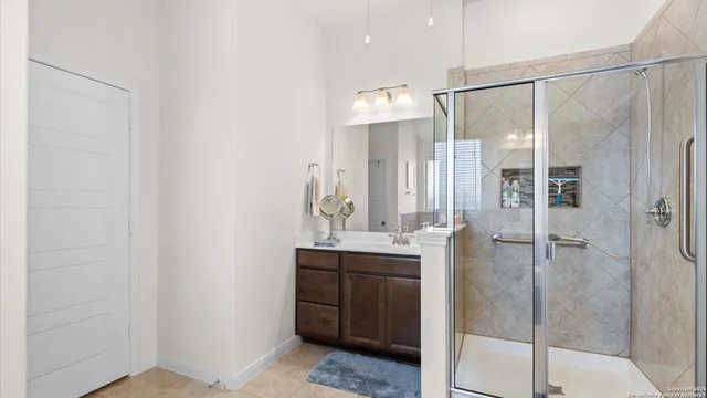 a bathroom with a shower sink and mirror