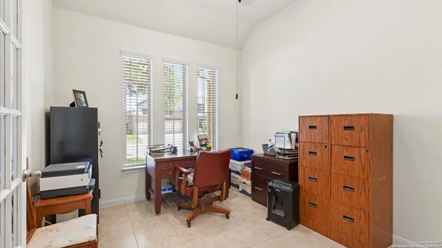 a view of a workspace with furniture and a window