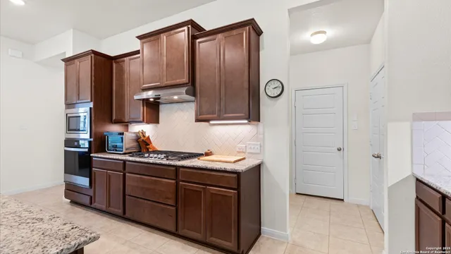 a kitchen with stainless steel appliances granite countertop a refrigerator and a stove top oven