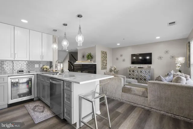 a large white kitchen with a stove a sink a dining table and chairs