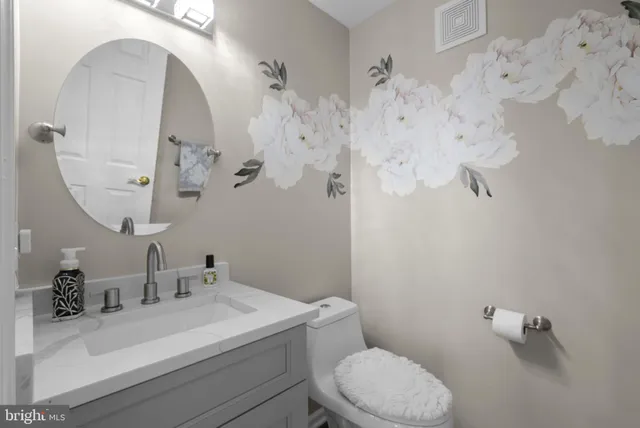 a bathroom with a sink mirror vanity and toilet