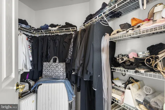 a view of walk in closet with clothes and shoes