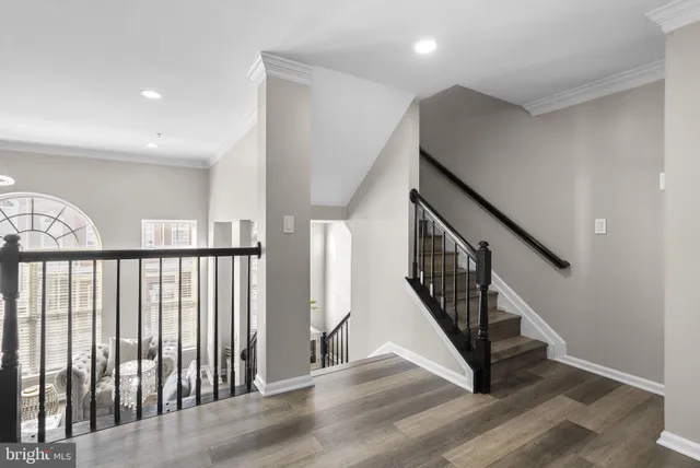 a view of staircase with railing and a wooden floor