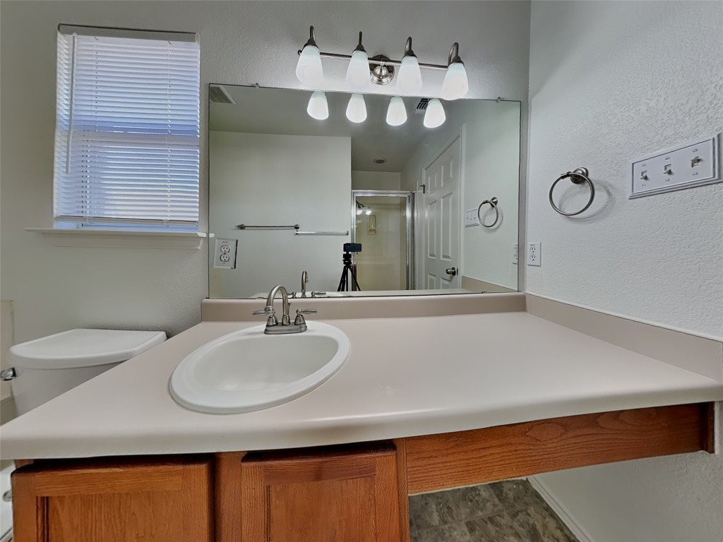 228 Fall Creek Drive Kyle, TX 78640 - Photo 11 of 19 Bathroom with vanity, a shower stall, and a textured wall