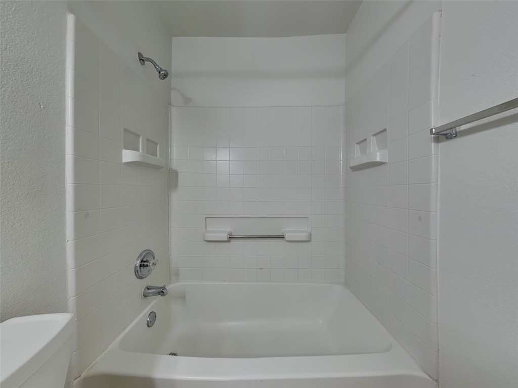 228 Fall Creek Drive Kyle, TX 78640 - Photo 16 of 19 Bathroom featuring bathing tub / shower combination and a textured wall