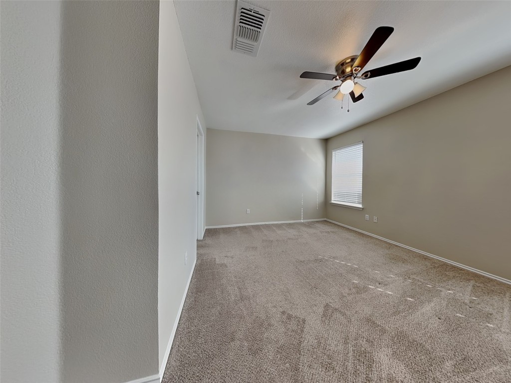 228 Fall Creek Drive Kyle, TX 78640 - Photo 8 of 19 Carpeted empty room with baseboards and ceiling fan