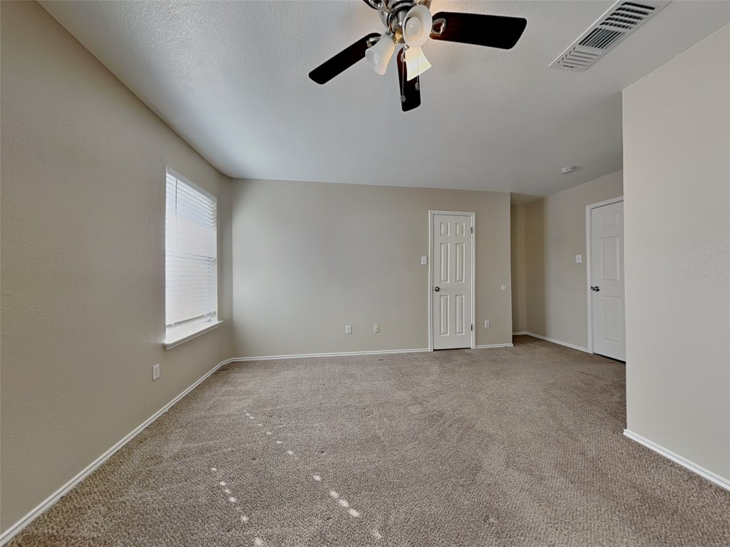 228 Fall Creek Drive Kyle, TX 78640 - Photo 9 of 19 Carpeted empty room with baseboards and a ceiling fan