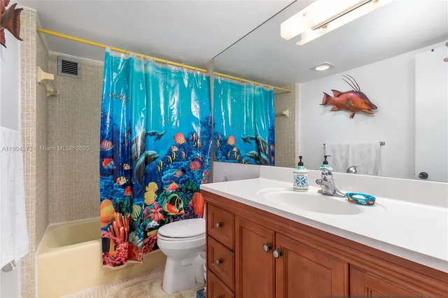 a bathroom with a sink vanity mirror and toilet