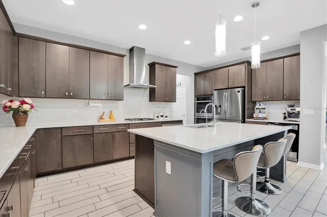 a kitchen with a sink a stove a refrigerator cabinets and chairs