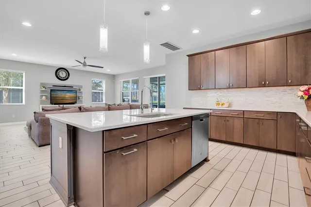 a kitchen with stainless steel appliances granite countertop a sink counter space cabinets and a large window