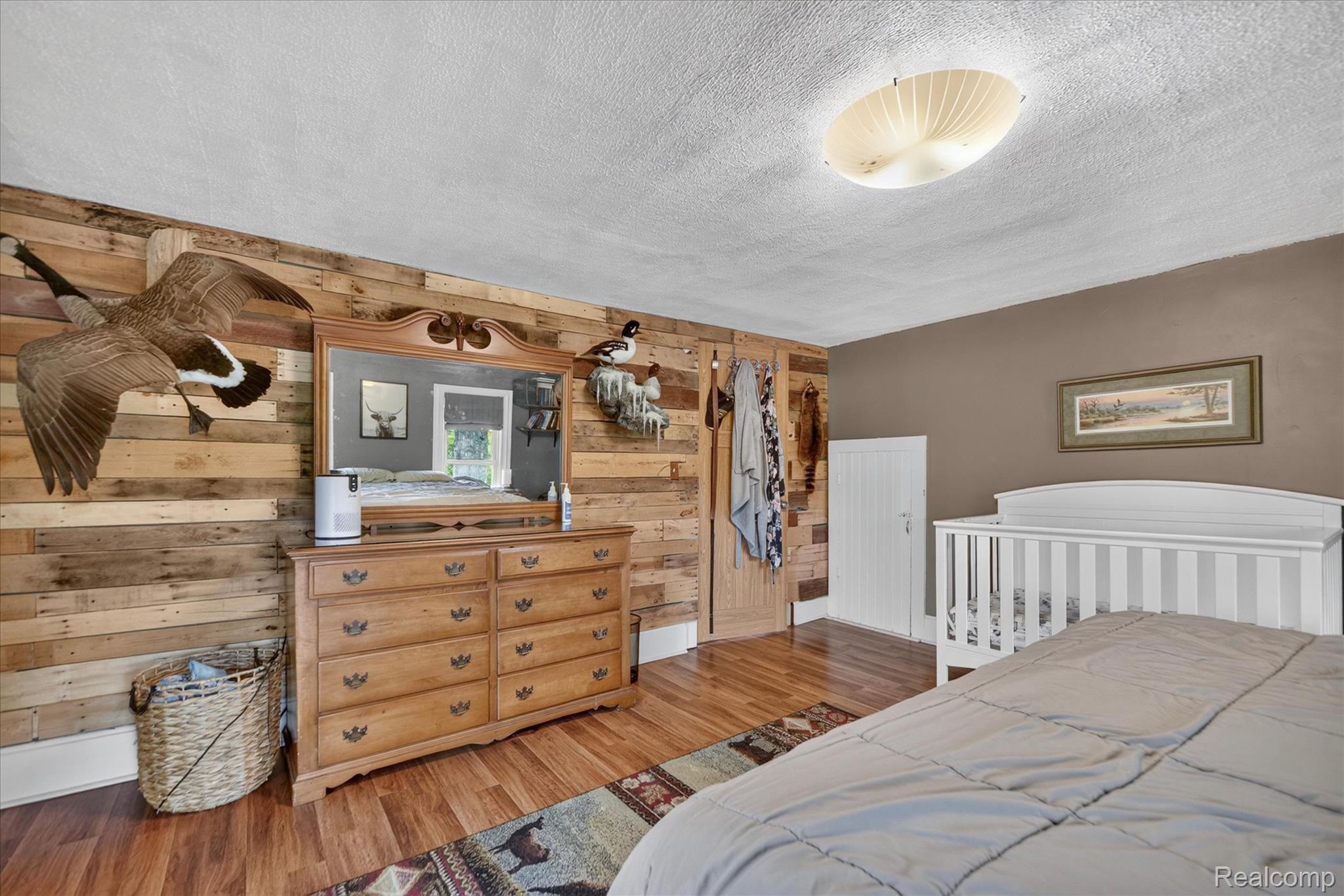 9413 Rives Junction Road Rives Junction, MI 49277 - Photo 18 of 43 Wood-finish flooring, accent wall with horizontal wood planks, semi-flush mount ceiling light, and a solid wood door