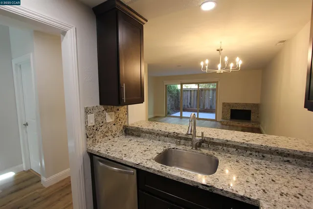 a kitchen with granite countertop a refrigerator and a sink