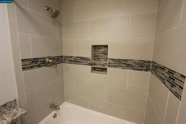 a bathroom with a granite countertop toilet sink and mirror