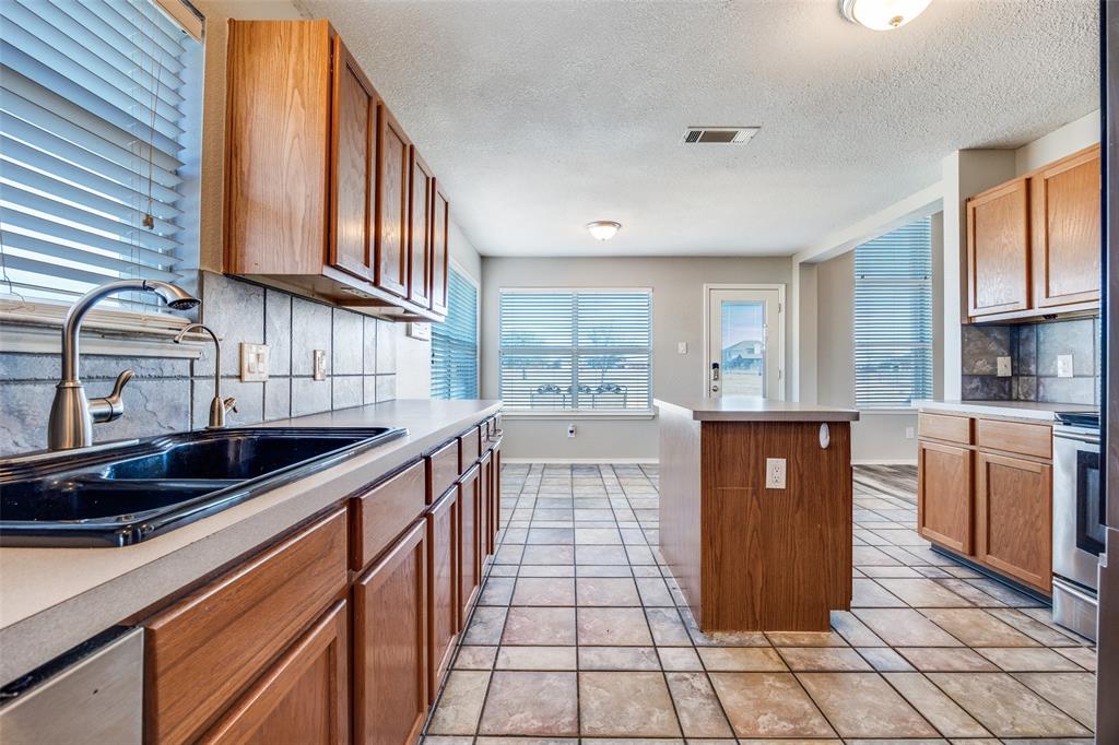 1026 County Road 544 Nevada, TX 75173 - Photo 9 of 32 a kitchen with stainless steel appliances granite countertop a sink and cabinets