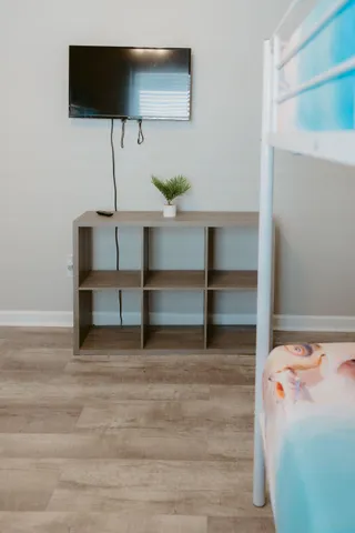 a bedroom with bed and a flat tv screen