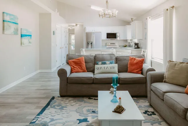 a living room with furniture and a view of kitchen