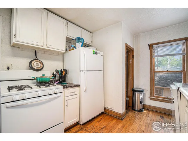 a kitchen with a refrigerator and a stove top oven
