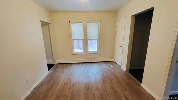 an empty room with wooden floor and window