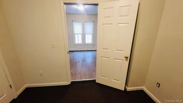 an empty room with wooden floor and white wall