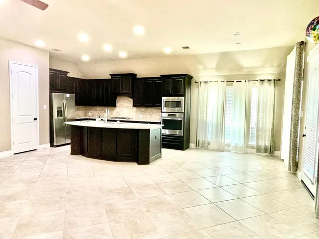 a view of kitchen with stainless steel appliances a sink and a refrigerator