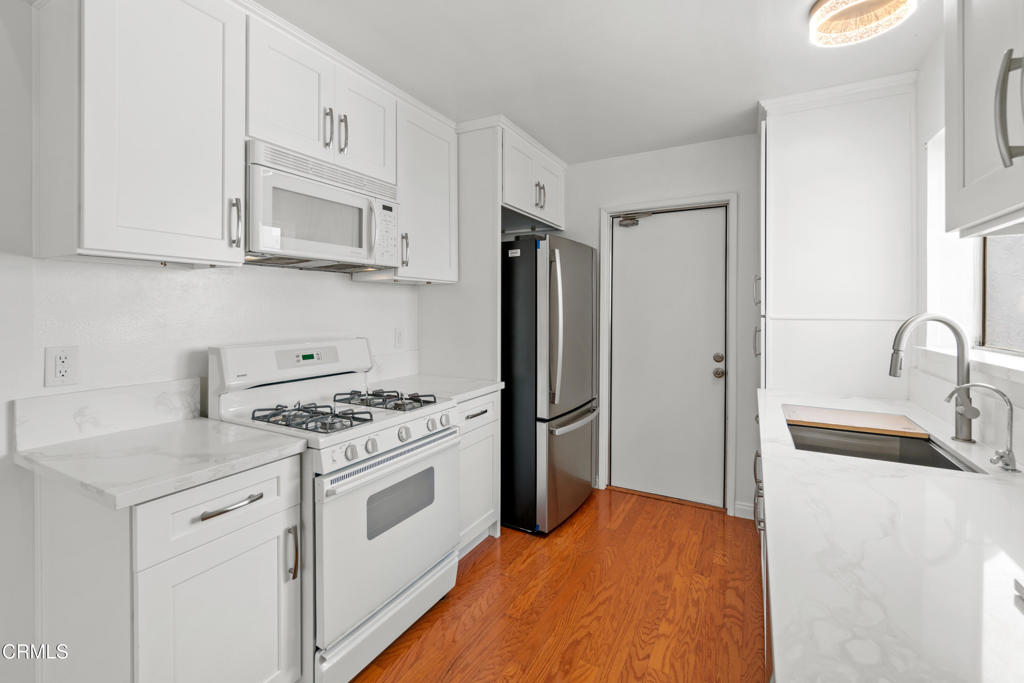 426 Reed Way Port Hueneme, CA 93041 - Photo 12 of 34 a kitchen with stainless steel appliances granite countertop a sink stove and refrigerator