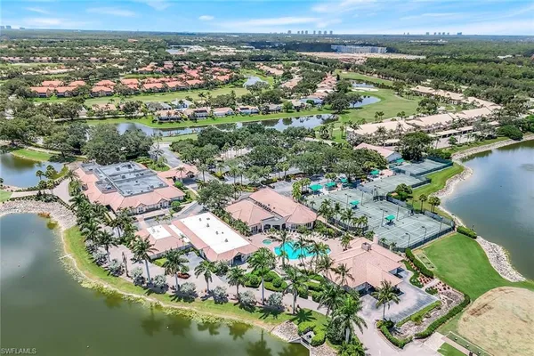 an aerial view of residential houses with outdoor space and lake view