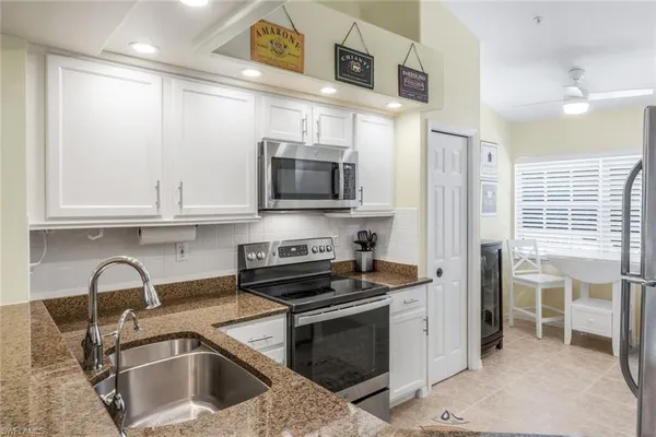 a kitchen with stainless steel appliances a stove a sink a microwave and cabinets