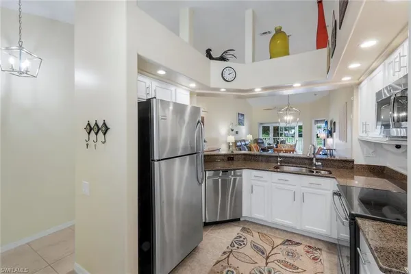 a kitchen with stainless steel appliances a refrigerator a sink a stove a dining table and chairs